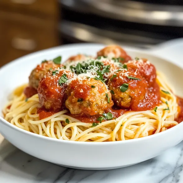 A bowl of pasta with meatballs.