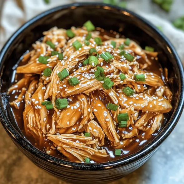 A bowl of food with green onions and chicken.