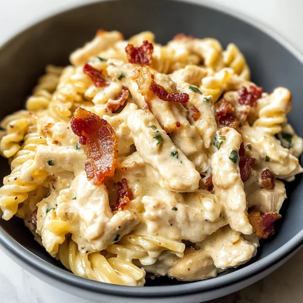 A bowl of pasta with bacon and cheese.