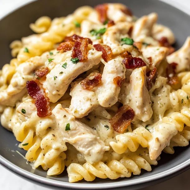 A plate of pasta with chicken and bacon.
