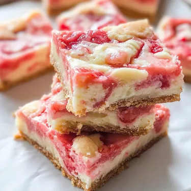 Lots of dessert bars stacked on a white plate.