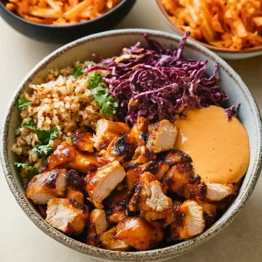 Chicken, grains, and veggies piled in a bowl.