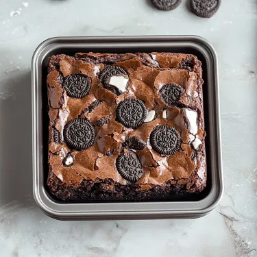 Square baking pan packed with brownies and topped with Oreos.