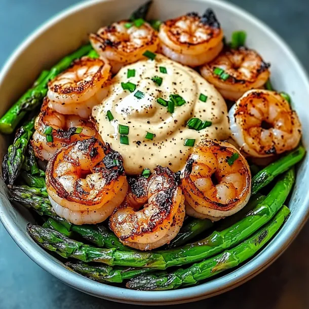 A bowl with asparagus and shrimp inside.