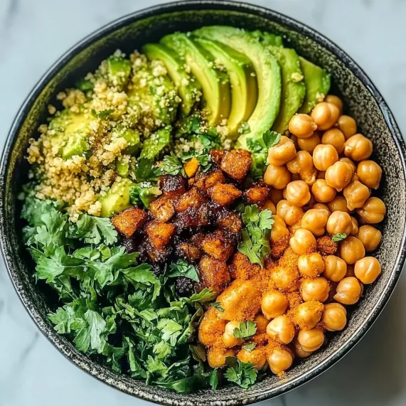 A bowl of food with avocado, chickpeas, and other ingredients.