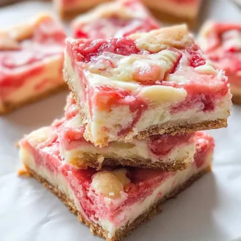 Lots of dessert bars stacked on a white plate.
