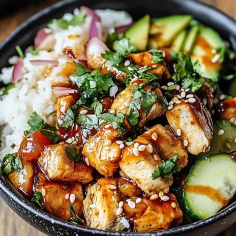 Lots of tasty chicken, rice, and veggies piled into a bowl.